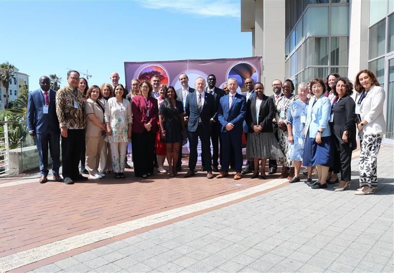 A diverse group of people in business attire stands outside a modern building.