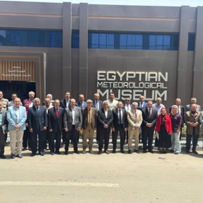 A large group of people stands in front of the Egyptian Meteorological Museum building for a group photo.
